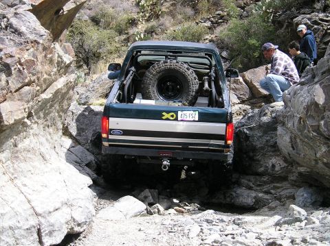 1993 Ford Bronco - This 1993 Ford Bronco navigates a challenging rocky terrain, its off-road capabilities with a rear-mounted spare tire.