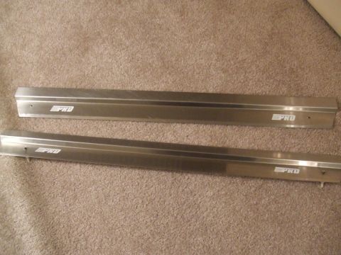 1995 Ford Probe - Two metal door sill plates, each marked with "PRO" text, are displayed on a carpeted floor.