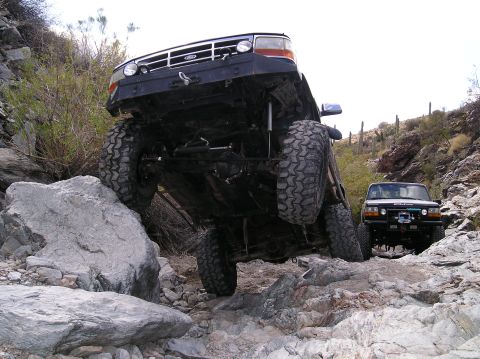 1993 Ford Bronco - A 1993 Ford Bronco navigates a rocky trail, demonstrating its off-road capabilities.