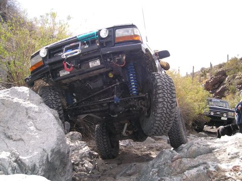 1993 Ford Bronco - Modified 1990s Ford Bronco tackling a challenging rocky off-road trail.