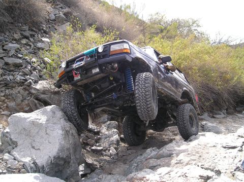 1993 Ford Bronco - This modified SUV is navigating a rocky trail, its off-road capabilities.