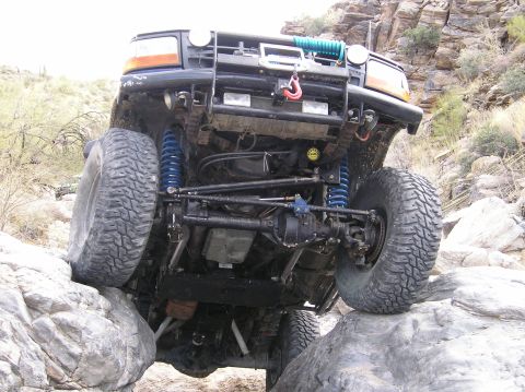 1993 Ford Bronco - This modified 1990s era SUV navigates a rocky trail, demonstrating its off-road capabilities.