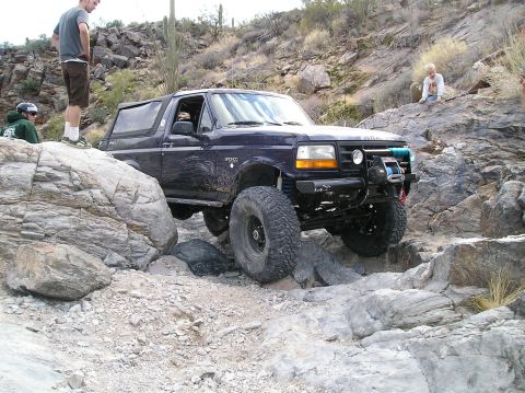 1993 Ford Bronco - A 1993 Ford Bronco tackles a challenging rocky terrain, demonstrating its off-road capabilities.