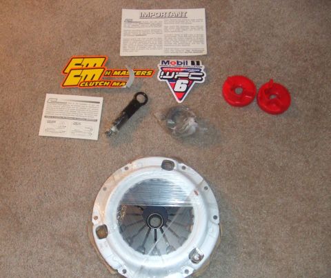 1995 Ford Probe - A clutch kit is laid out on a carpeted surface, including a pressure plate, clutch disc, installation instructions, and various sponsor sti…