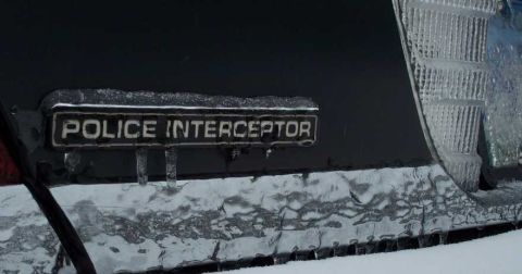 1998 Ford Crown Victoria - This vehicle's 'Police Interceptor' badge is covered in ice and icicles, suggesting cold weather conditions.