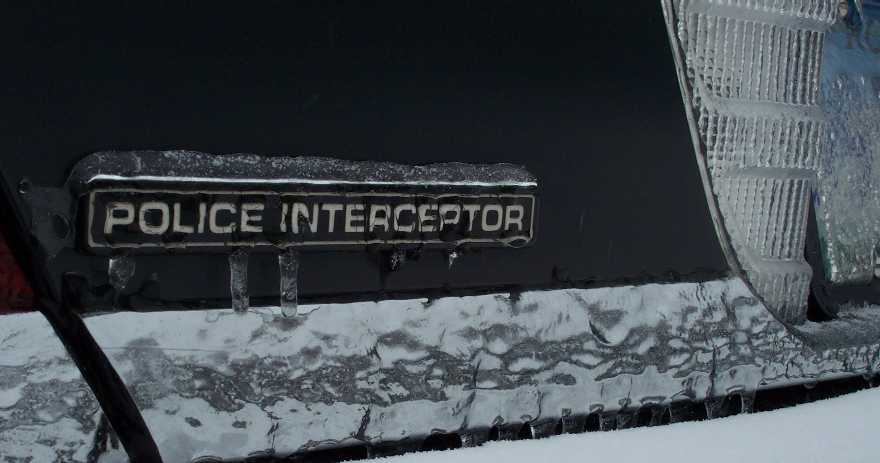 Iced-over 'POLICE INTERCEPTOR' chrome emblem on dark car body panel