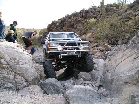 1993 Ford Bronco - This heavily modified Chevrolet pickup truck is shown off-roading on a challenging rocky trail.