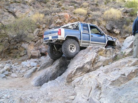 1993 Ford Bronco - A modified Chevrolet pickup truck navigates a rocky, off-road trail.