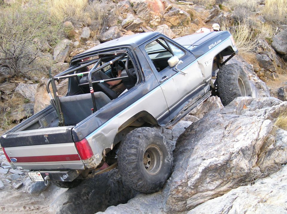 1993 Ford Bronco climbing rocks, modified with roll cage and large tires
