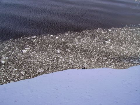2000 Chevrolet Tahoe - Ice floes on dark water next to a snowy bank. Supermotors.net logo visible.