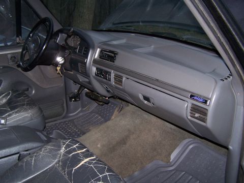 1992 Ford Bronco - The interior of a 1992 Ford Bronco shows cracked leather seats and a gray dashboard with a prominent 'Eddie Bauer' badge.