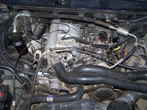 1992 Ford Bronco - A close-up view of a complex engine bay, showing numerous hoses, wires, and mechanical components.