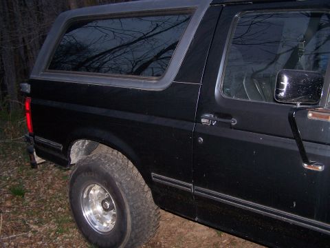 1992 Ford Bronco - Side view of a black 1992 Ford Bronco with aftermarket wheels.
