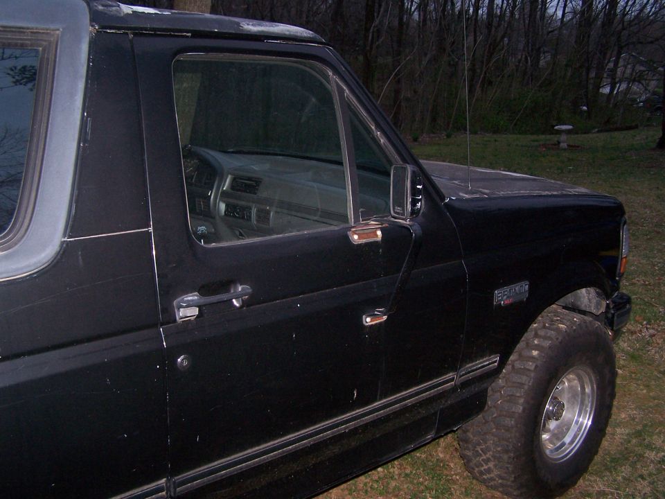 Black Ford Bronco, driver's side view, showing door and front fender