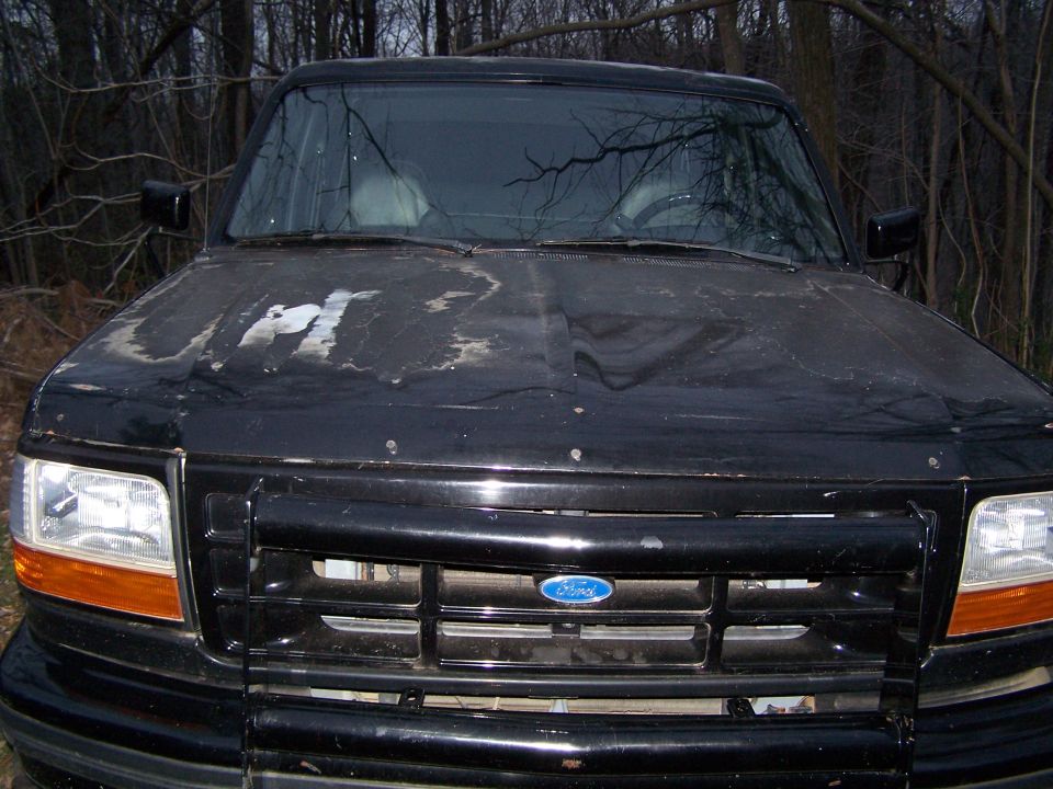 Black 1992 Ford Bronco front view, hood paint peeling, grille intact