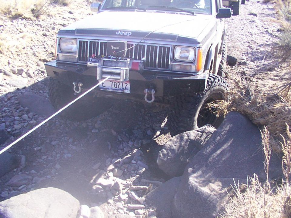 Jeep Cherokee XJ with winch on rocky trail, another vehicle behind