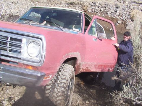 1978 Ford Bronco - A red 1970s Dodge Ramcharger navigates rough terrain with its door open.