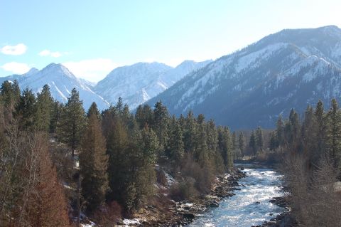 2001 Ford Taurus - A scenic view of snow-capped mountains, a flowing river, and evergreen trees under a clear blue sky. The Supermotors logo is present in the…