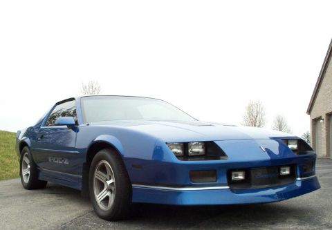 1990 Chevrolet Camaro - A blue 1990 Chevrolet Camaro IROC-Z is shown from a 3q-front angle, parked outdoors.