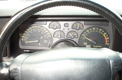 1990 Chevrolet Camaro - Interior view of a car's dashboard, showing various gauges and the steering wheel. The odometer displays 074555 miles.