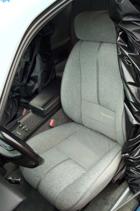 1990 Chevrolet Camaro - The interior of a 1990 Chevrolet Camaro is shown, the driver's seat and center console with controls.