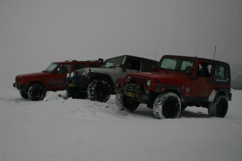 2003 Jeep TJ - Several Jeeps and a Jeep Cherokee are parked in a snowy landscape.