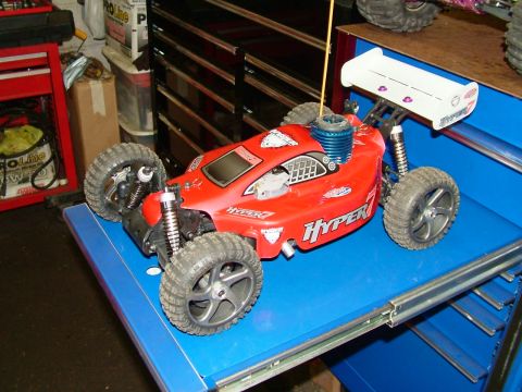 1994 Ford Bronco - A red remote control buggy with "HYPER 7" graphics sits on a blue surface.
