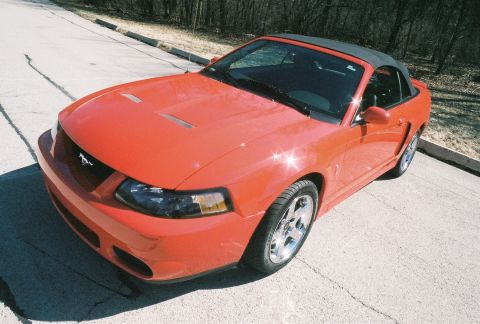 2004 Dodge SRT-4 - This red convertible sports car has a black soft top and distinctive hood scoops.