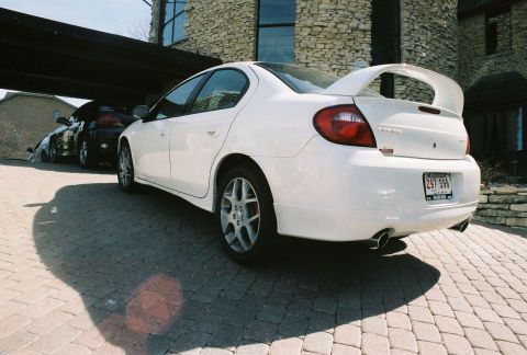 2004 Dodge SRT-4 - Rear view of a white 2004 Dodge Neon SRT-4, showing its distinctive spoiler and dual exhaust pipes.