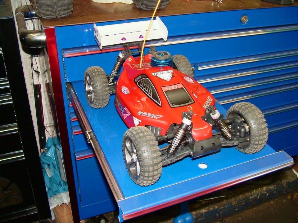 Red remote control car with white spoiler and "HYPER 7" graphics