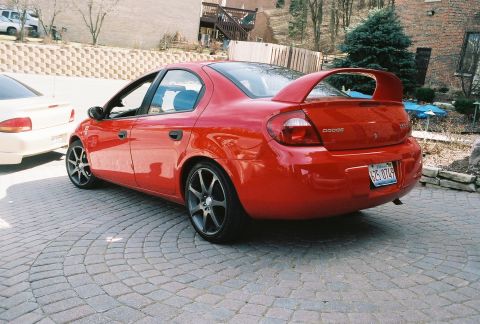 2004 Dodge SRT-4 - Rear view of a red 2004 Dodge SRT-4 with a prominent spoiler and aftermarket wheels.