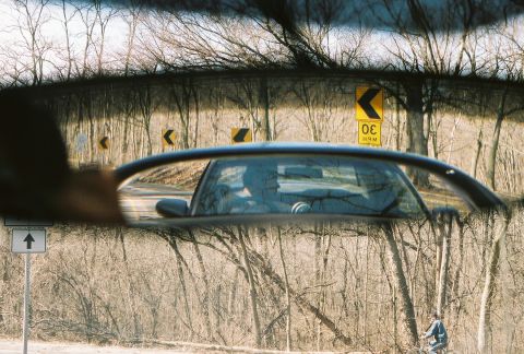 2004 Dodge SRT-4 - View from inside a car, showing the side mirror reflecting the driver and the road ahead.