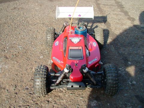 1994 Ford Bronco - This red remote control buggy features a white spoiler and a visible blue engine cover, with 'HYPER 7' branding on its body.