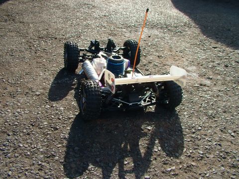 1994 Ford Bronco - A radio-controlled car with a visible engine and antenna sits on a gravel surface.