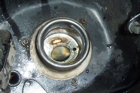 1994 Ford F-150 - The fuel filler neck of a vehicle shows some wear and tear around the opening.
