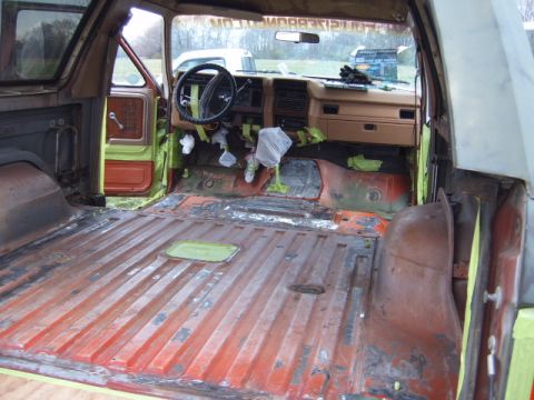 1988 Ford Bronco - Interior view of a 1988 Ford Bronco undergoing restoration, with seats removed and floor exposed.