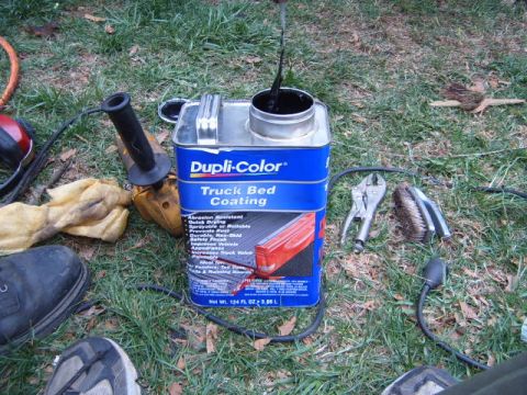 1988 Ford Bronco - Tools and a can of truck bed coating are laid out on the grass.