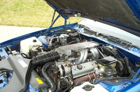 1990 Chevrolet Camaro - Engine bay of a 1990 Chevrolet Camaro, viewed from the front with the hood raised.
