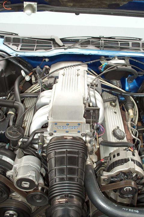 1990 Chevrolet Camaro - The engine bay of a car, the intake manifold, air intake, and alternator.