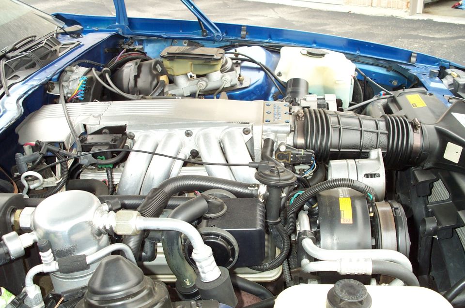 Blue Chevrolet Camaro engine bay with V8 engine, air intake, and AC compressor visible