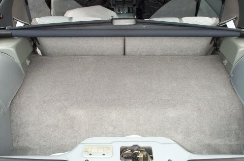 1990 Chevrolet Camaro - The trunk of a 1990 Chevrolet Camaro features grey carpeting and a retractable cargo cover.