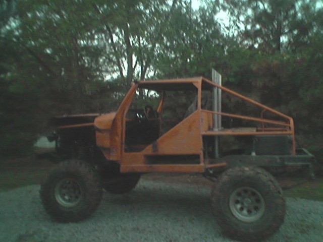 custom off-road vehicle with roll cage and tall exhaust pipe, side view