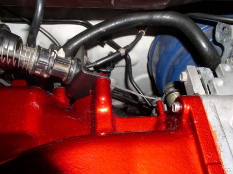 1996 Ford Probe - Close-up view of a red painted engine intake manifold, showing various hoses and cables connected to it.