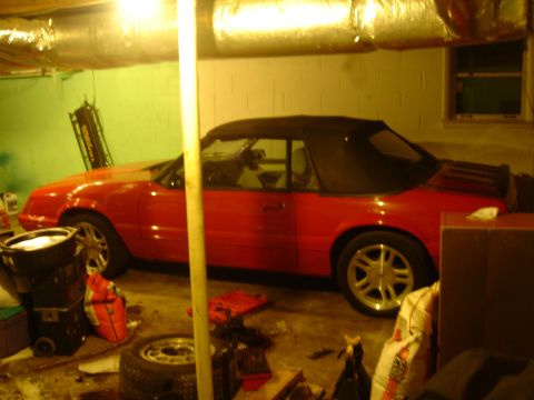 1986 Ford Mustang - Red convertible, likely a 1987 Ford Mustang, parked indoors with the top down.