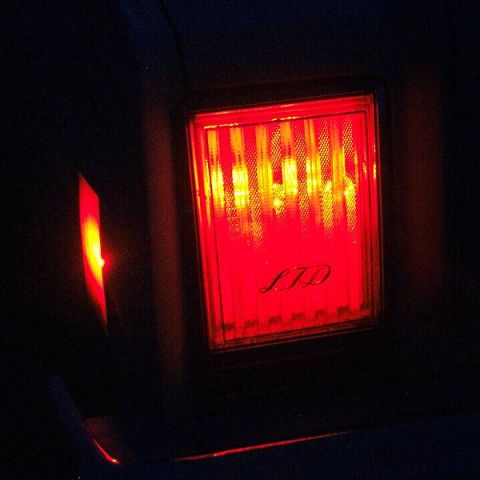 1985 Ford LTD Crown Victoria - The illuminated taillight assembly features the 'LTD' script, with a smaller red light element to its side.