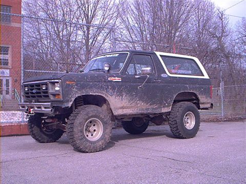 1986 Ford Bronco - This lifted 1986 Ford Bronco is shown in a three-quarter front view, covered in mud.