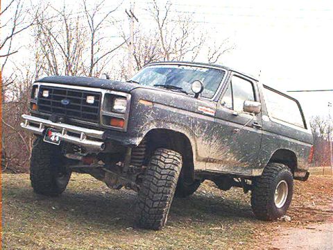 1986 Ford Bronco - This lifted Ford Bronco is covered in mud, suggesting it has seen some off-road action.