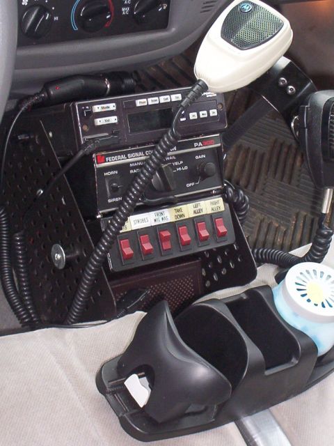 2002 Ford Crown Victoria - Close-up of a police vehicle's interior, showing communication and control equipment.
