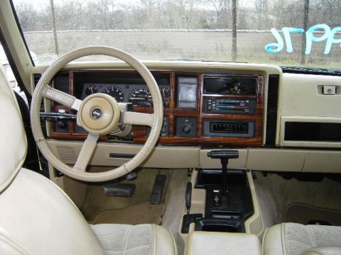 1993 Jeep Cherokee - The interior of a 1993 Jeep Cherokee features a wood-grain dashboard and beige upholstery.