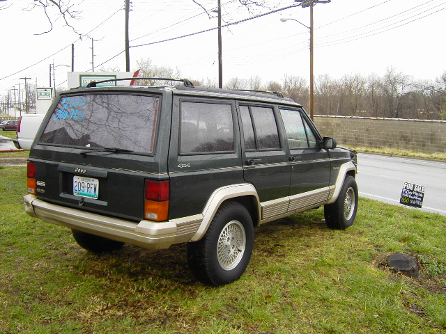1993 Jeep Cherokee parked on grass, rear view. License plate 209-RFW